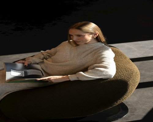 Person relaxing and reading a book on a comfortable chair